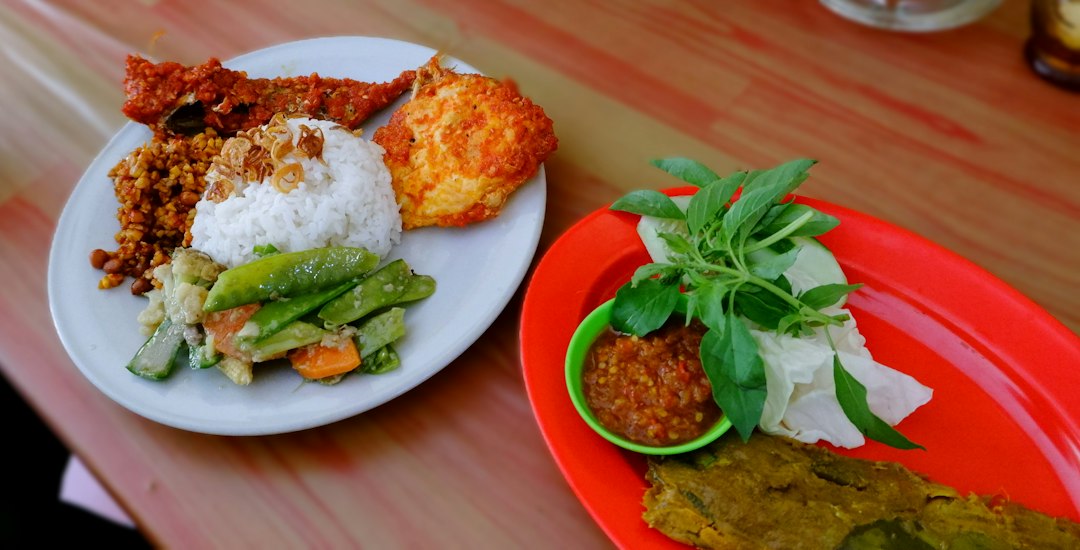 Hidangan nasi dengan telur balado dan ikan, menu makan siang saat singgah naik mobil travel Pekanbaru-Medan